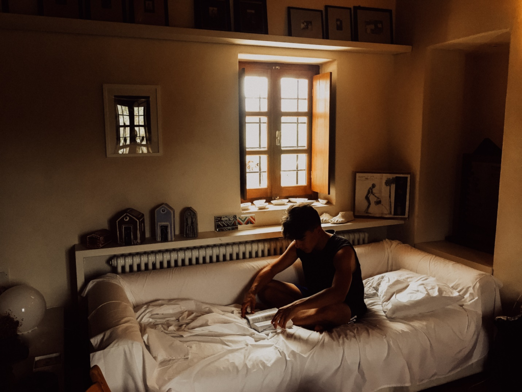 A man sitting on his bed