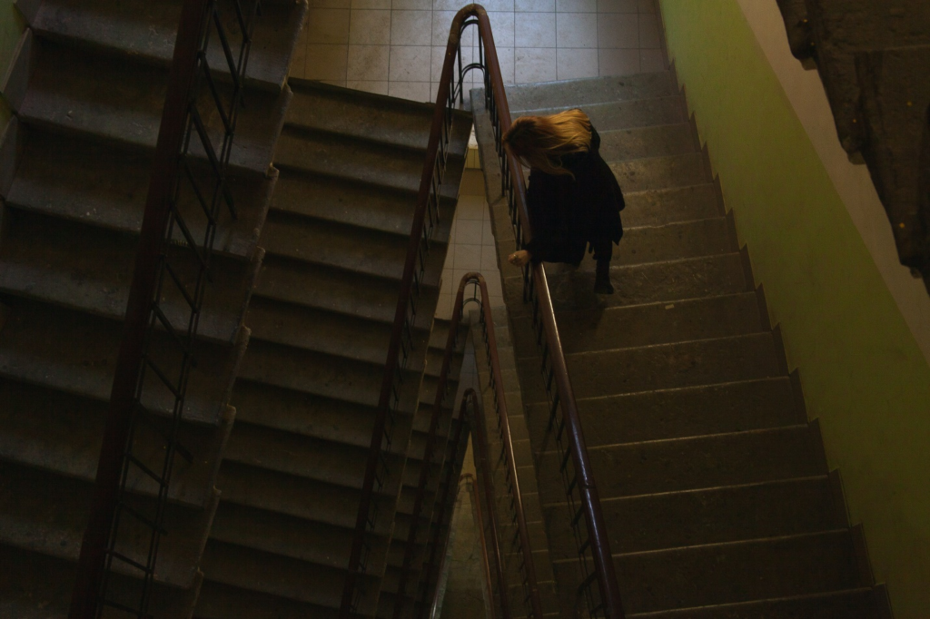 woman climbing stairs of an apartment building  